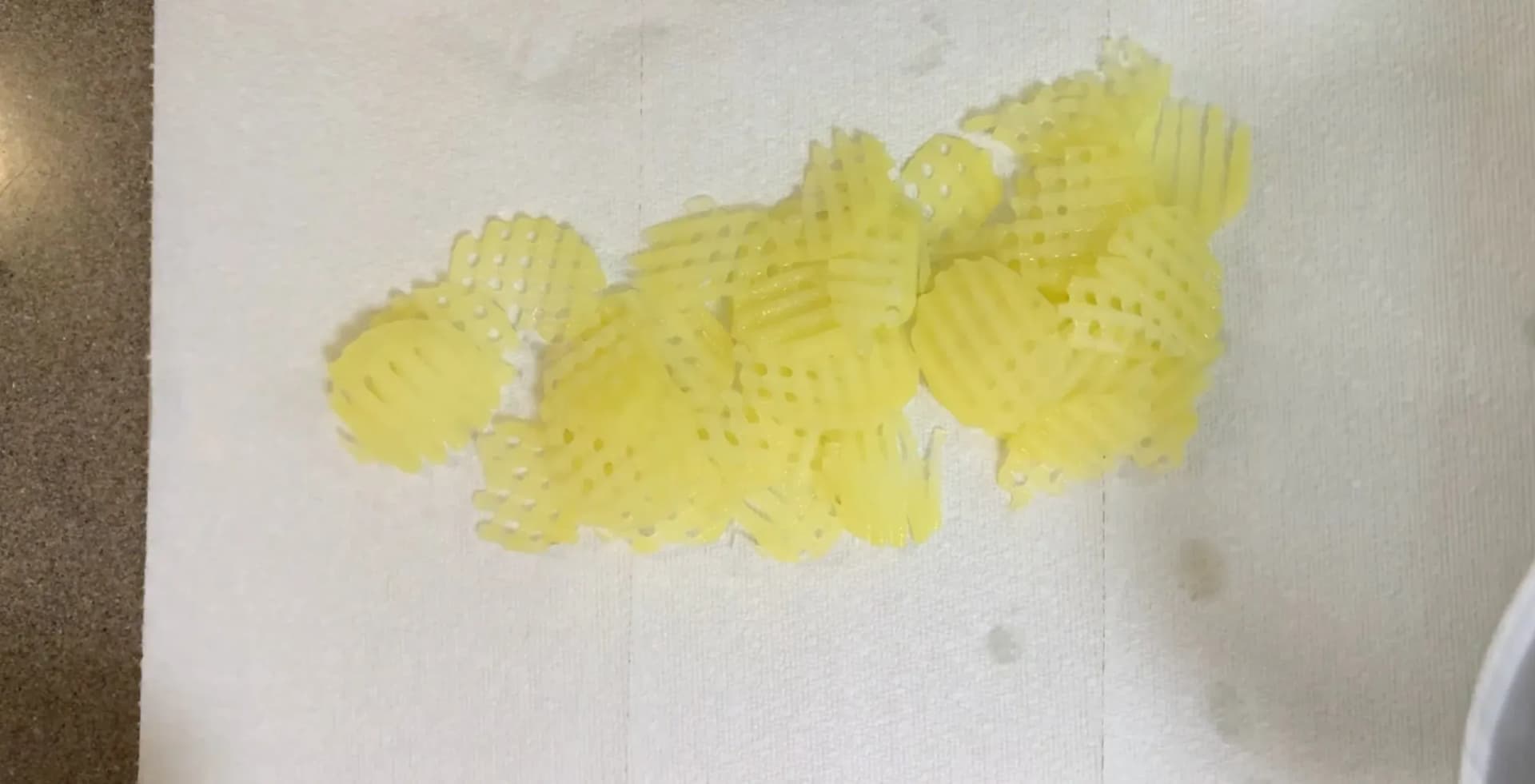 Olive oil-coated potato strips on paper towel, ready for air frying.