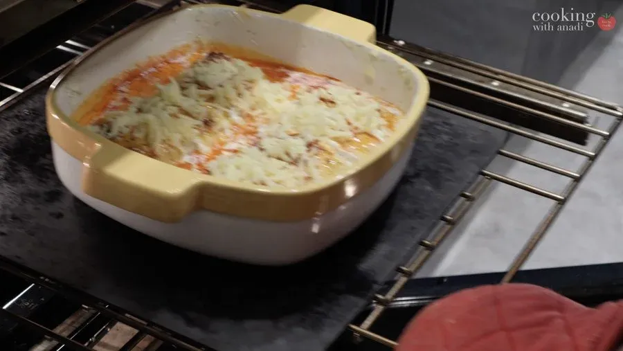 Gluten-free strukli baking in a ceramic dish with melted cheese and cream sauce bubbling in the oven.
