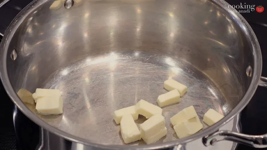 Butter pieces melting in a stainless steel pot for St. Patrick's Day Guinness Chicken Pot Pie.