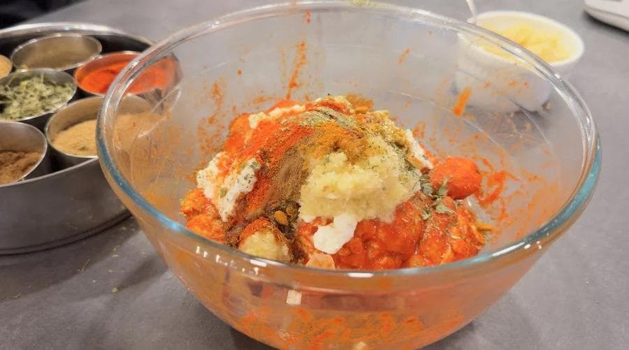 Second marinade ingredients mixed in bowl with yogurt, spices, and ginger-garlic paste ready for marinating.