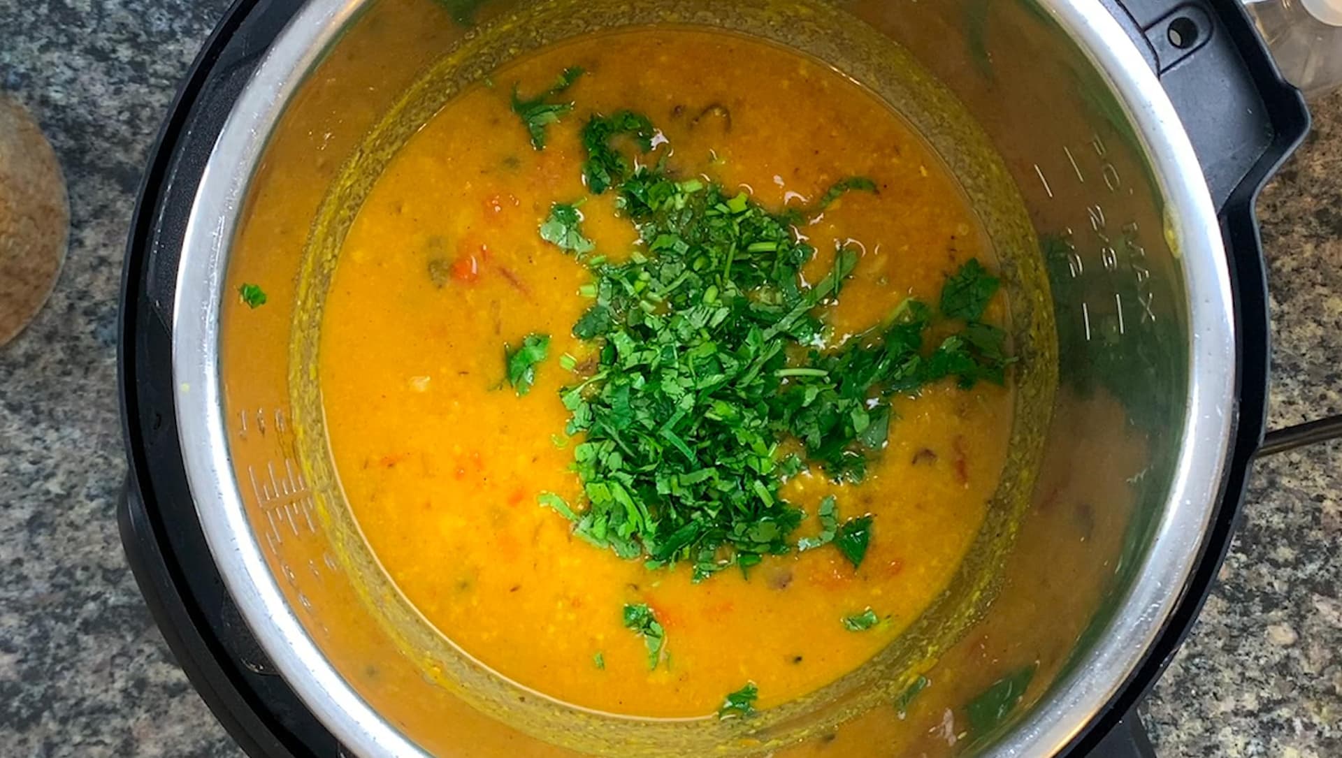 Instant Pot of golden chana dal soup topped with fresh chopped cilantro garnish