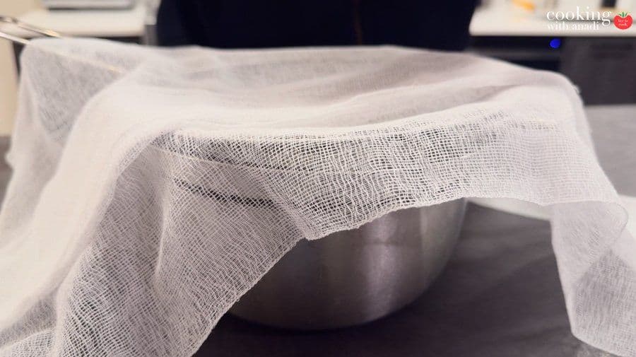 Cheesecloth draped over a stainless steel bowl, ready to strain yogurt for hung curd.