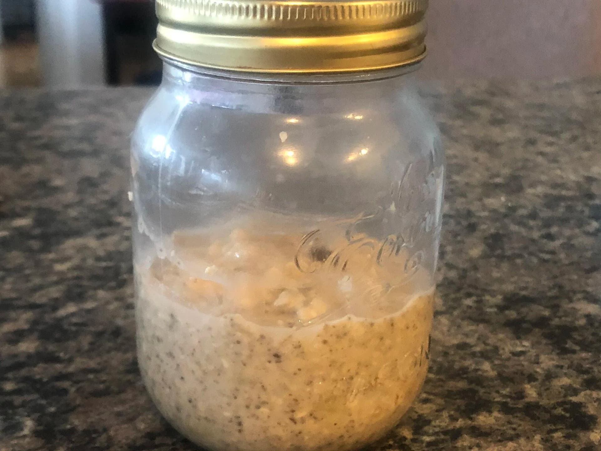 Coconut Banana Chocolate Chip Overnight Oats in a mason jar with gold lid, showing creamy tan mixture with visible oat pieces.