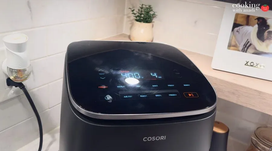 Cosori air fryer display lit up showing 400°F, preheating for taquitos preparation.