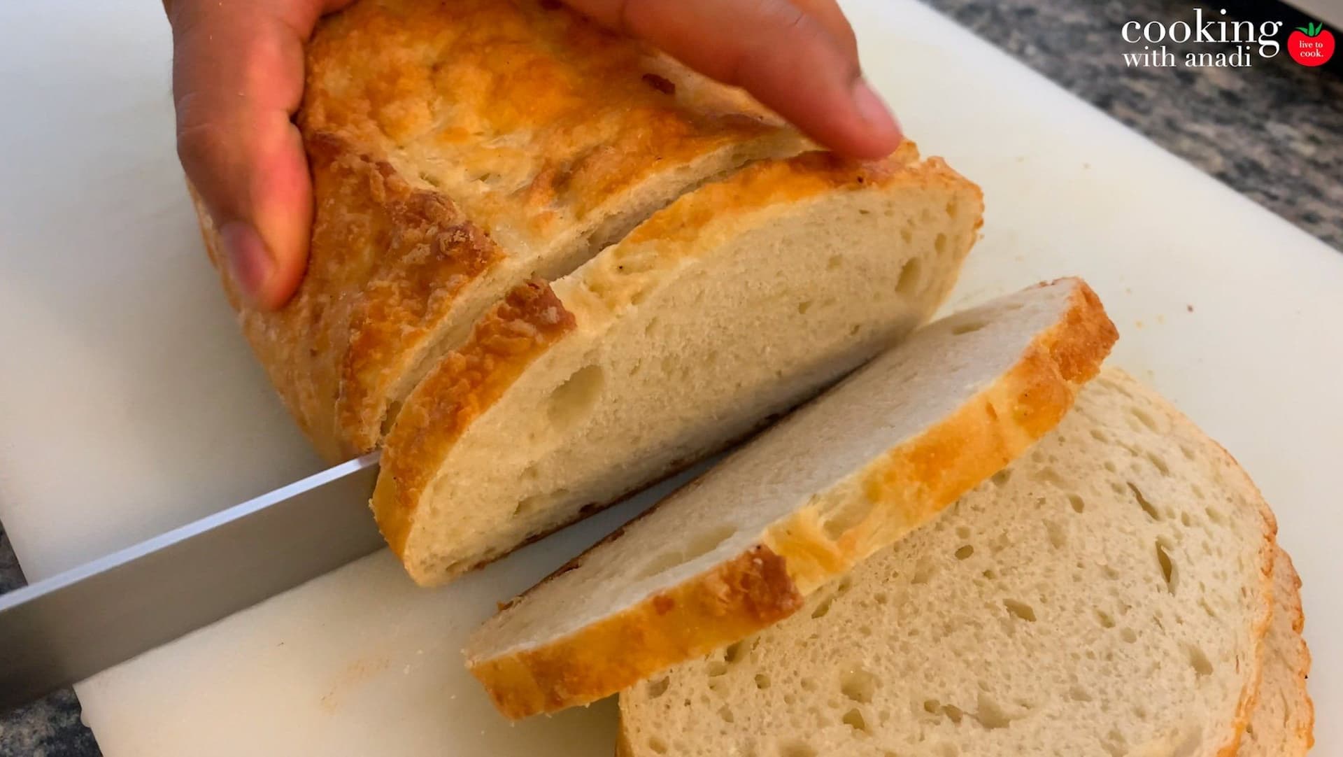 Slicing toasted bread with a serrated knife, showing golden crust and soft interior crumb structure.