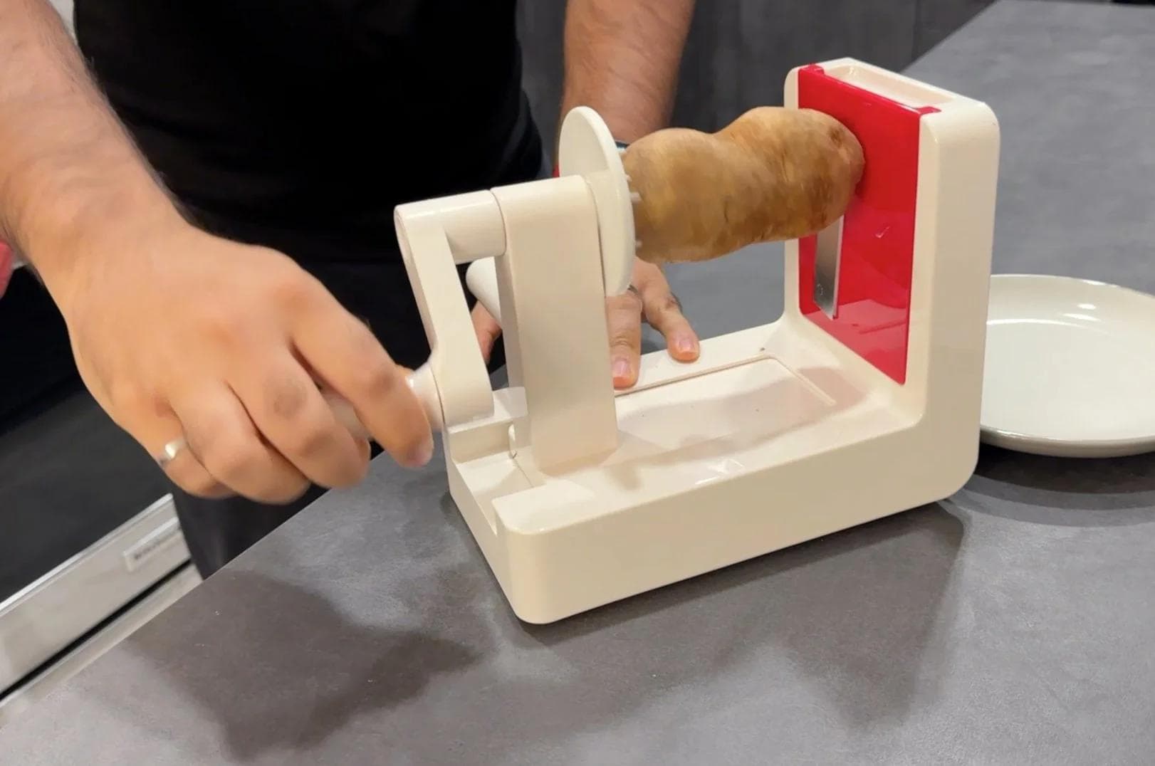 Using a spiralizer with flat blade attachment to thinly slice a potato for the tart filling.