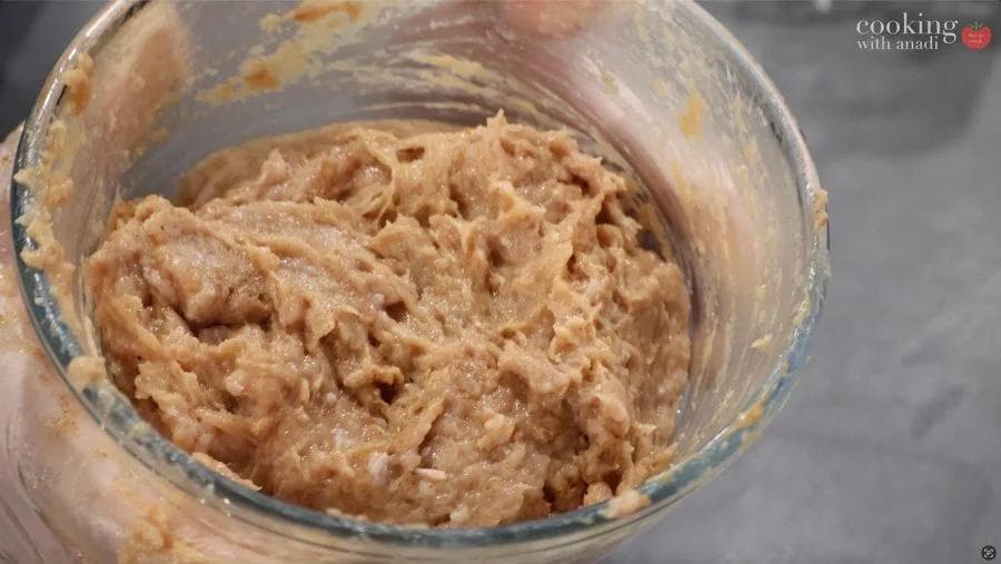 Ground chicken mixture blended with egg and cornstarch in a glass bowl for chicken nuggets.