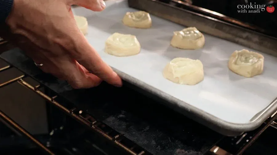 Mashed potato pinwheels arranged on parchment paper on a baking sheet ready for baking.