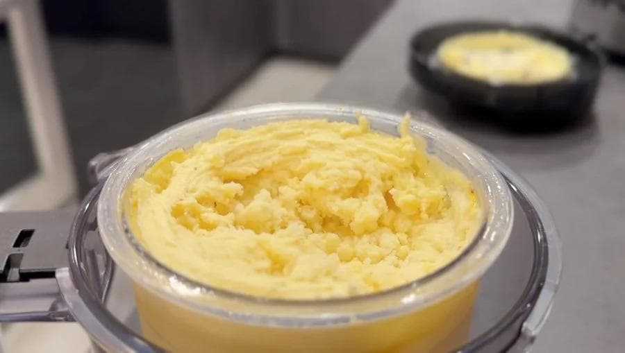 Creamy pale yellow Indian sooji kheer ice cream in a Ninja Creami container after processing.