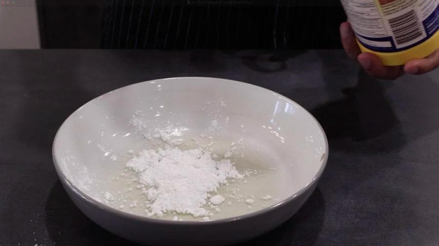 White bowl containing flour and other dry breading ingredients for chicken nuggets.