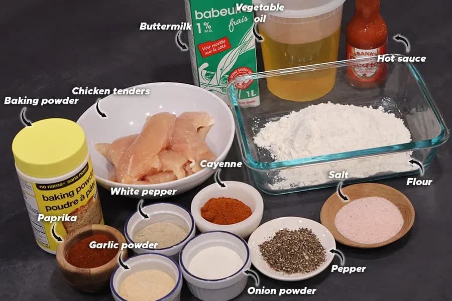 Labeled ingredients for crispy chicken tenders: raw chicken, buttermilk, flour, spices, hot sauce, vegetable oil, and baking powder.