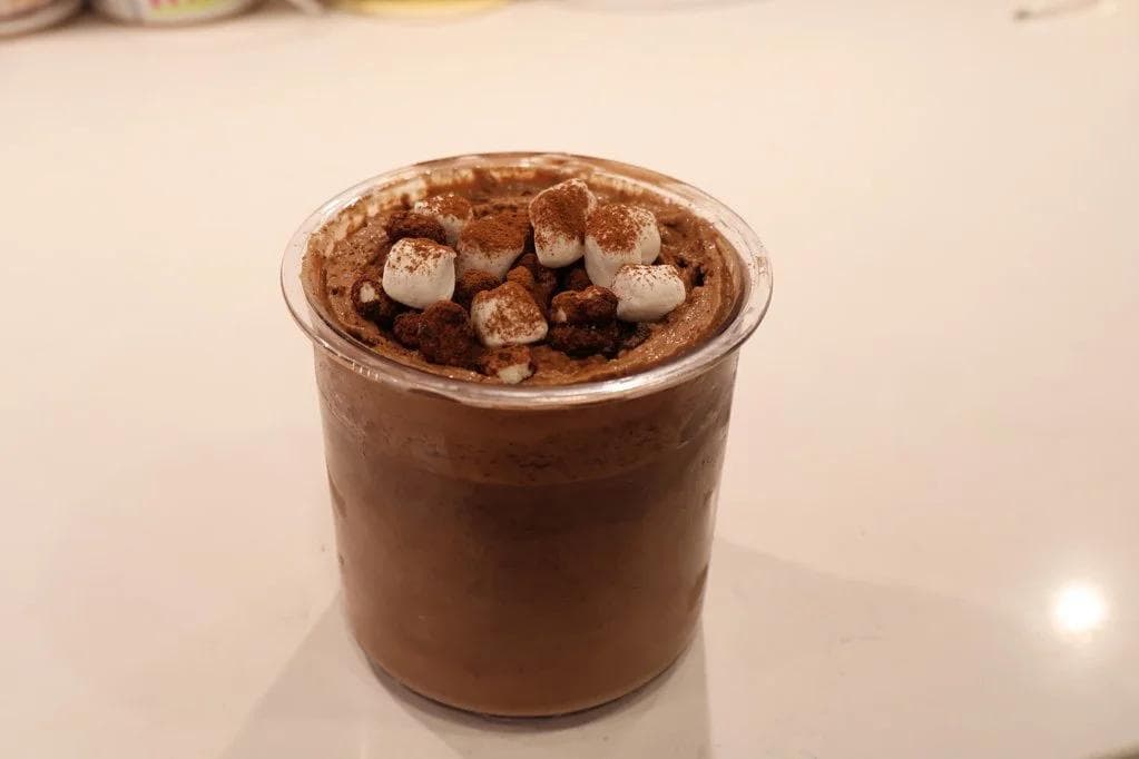 Homemade frozen hot chocolate McFlurry in a clear cup topped with cocoa powder and marshmallows.