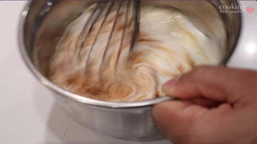 Whisking pumpkin cream cheese filling in a stainless steel bowl until well combined and smooth.