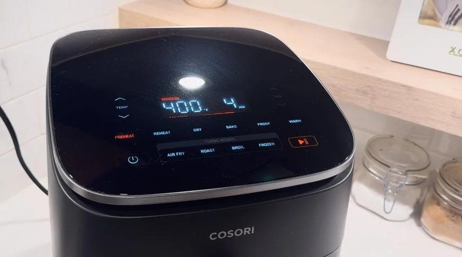 Cosori air fryer preheated to 400°F with digital display showing temperature setting.