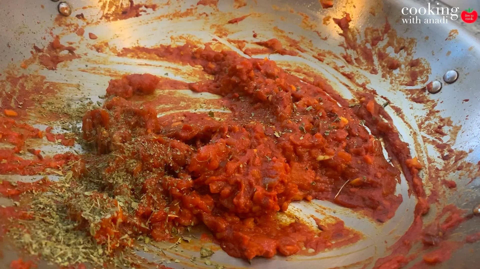 Creamy tomato-based tikka masala sauce with ground spices and dried fenugreek leaves in a pan before adding cream and chicken.