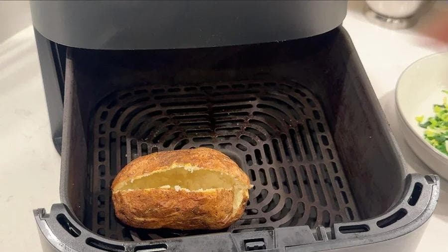 Crispy potato shell in air fryer basket after crisping at 390°F for 3-4 minutes.