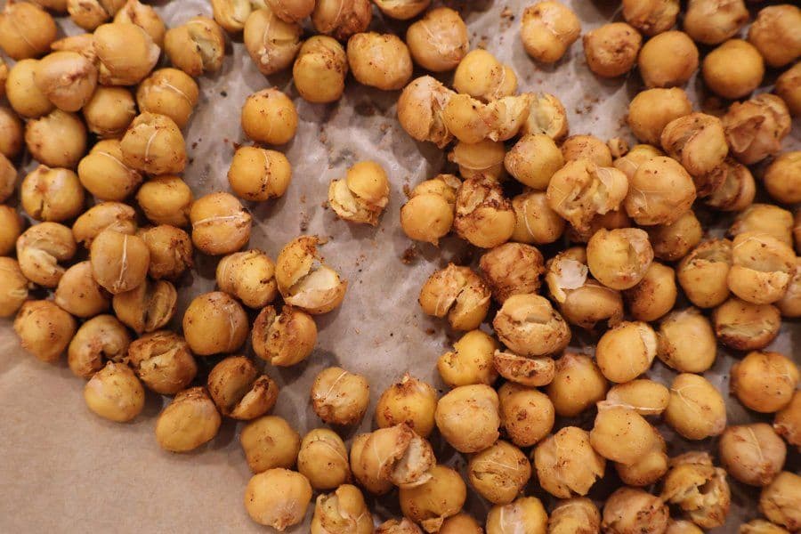 Golden, crispy roasted chickpeas on parchment paper, perfectly cooked and seasoned.
