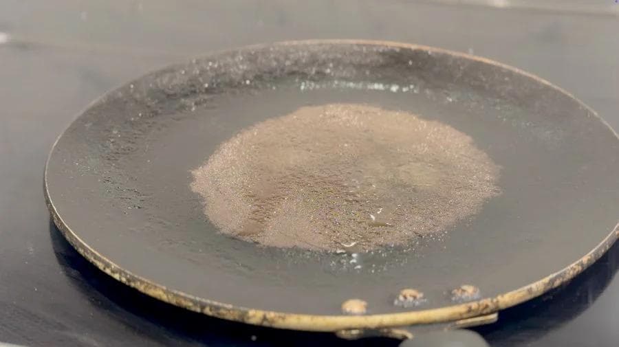 Butter melting in a skillet on medium heat, ready for toasting a frozen breakfast burrito.