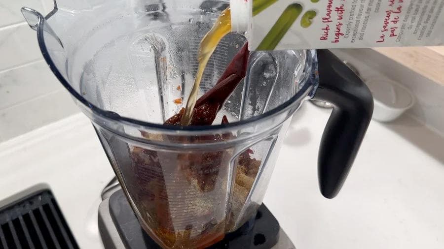 Blended birria sauce mixture in a blender pitcher with dried chiles, spices, and liquid before transferring to Instant Pot.