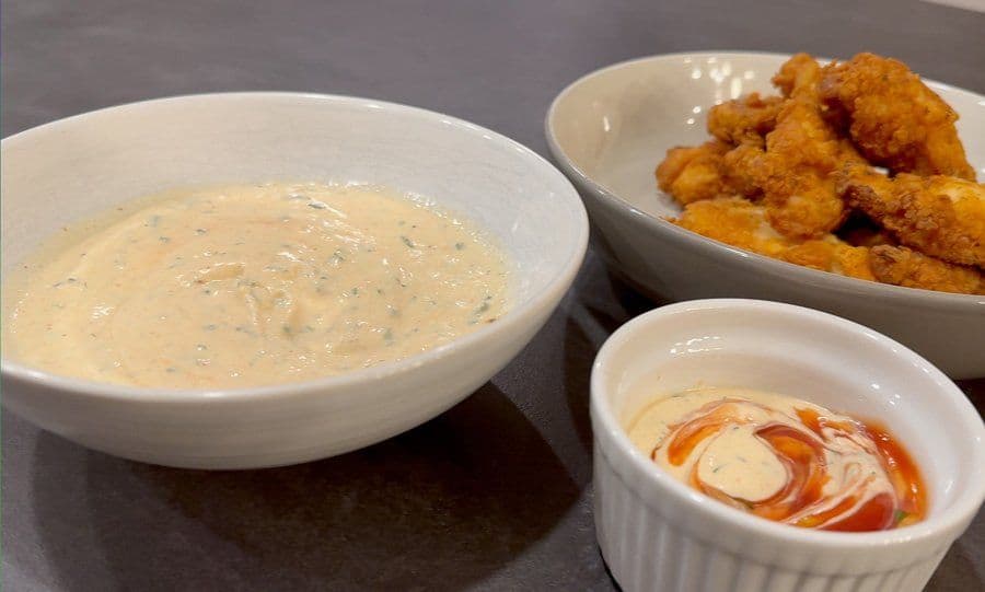 Homemade ranch dip in white bowl with fried shrimp and sriracha mayo sauce for dipping.