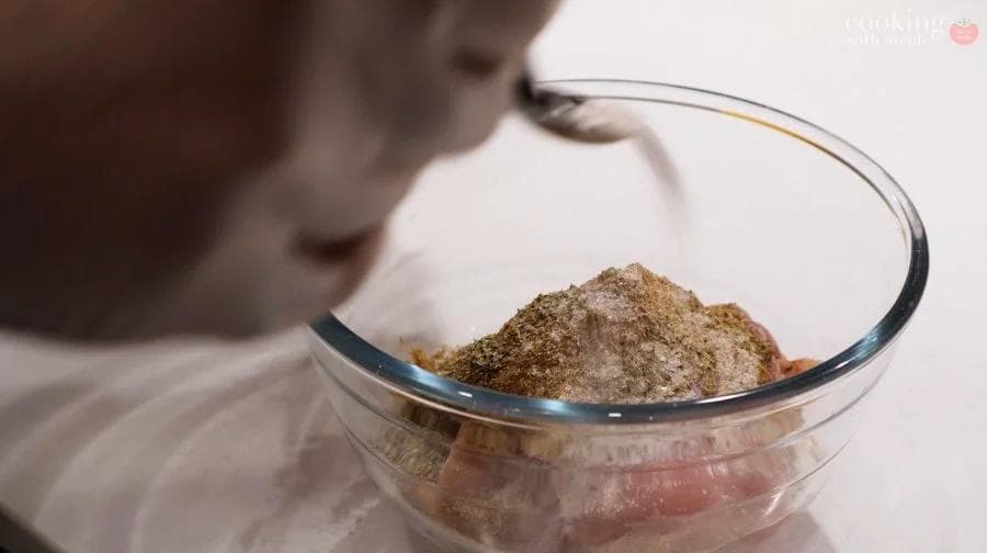 Dry spice mixture of salt, oregano, cumin and black pepper in a clear glass bowl.
