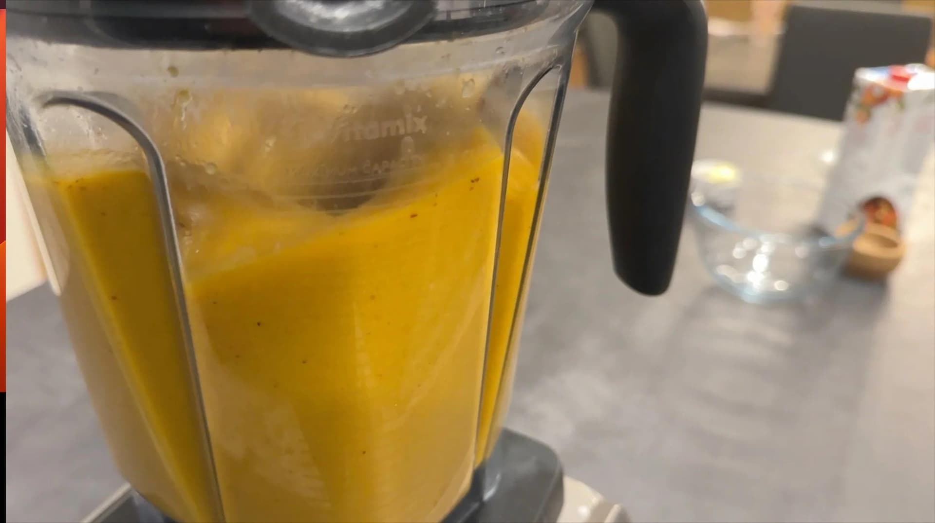Blended butternut squash mixture in food processor, smooth and creamy yellow-orange in color.