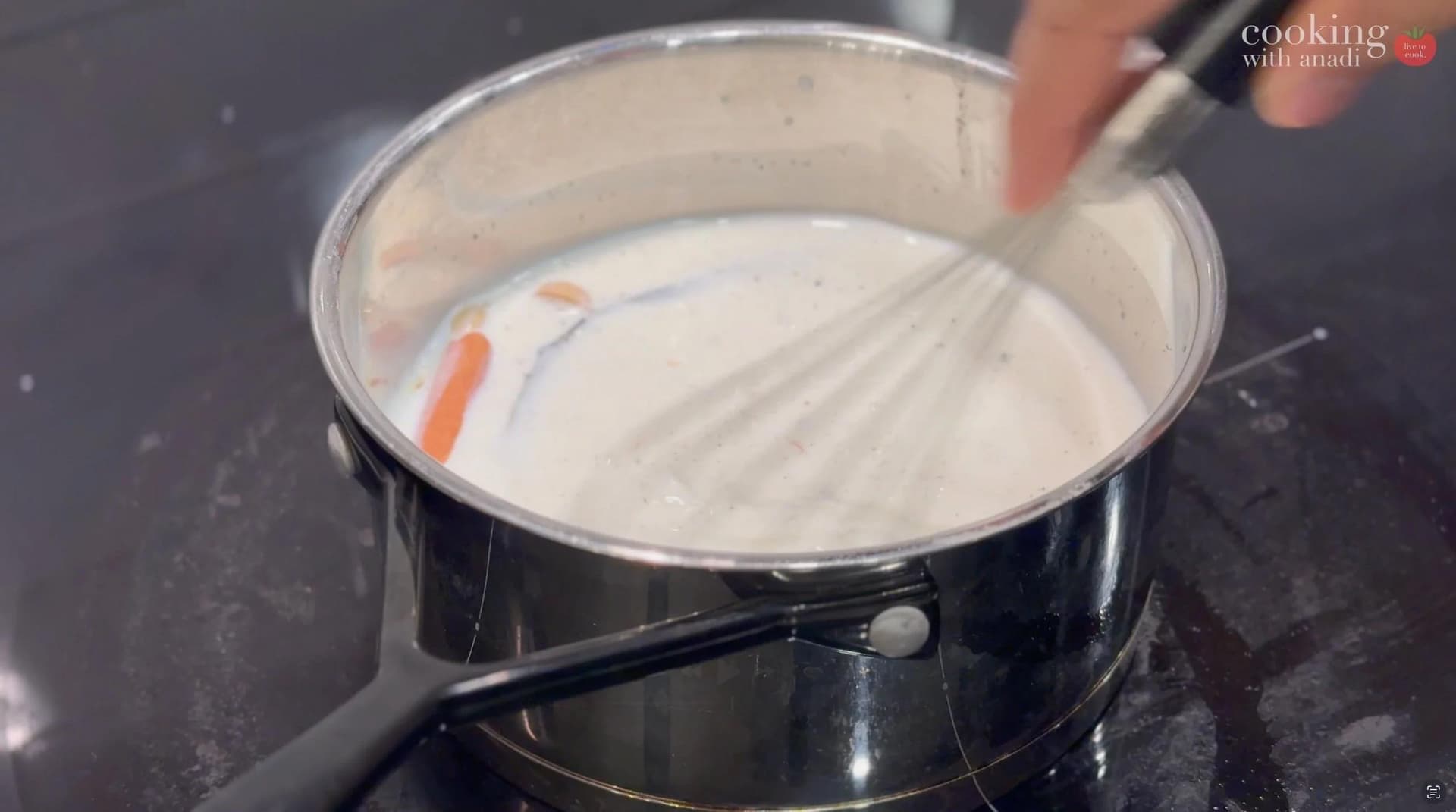 Heating milk with vanilla bean, cinnamon stick, cardamom pods, and saffron in a saucepan until steaming.