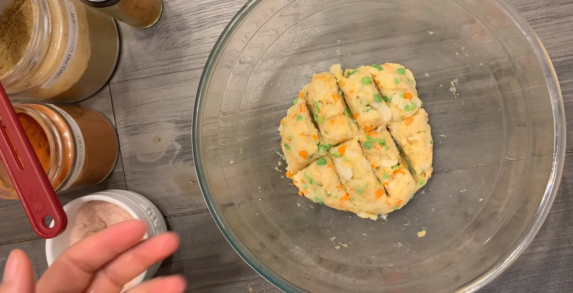 Potato patty mixture divided into 8 portions and shaped into a flattened round in a glass bowl.