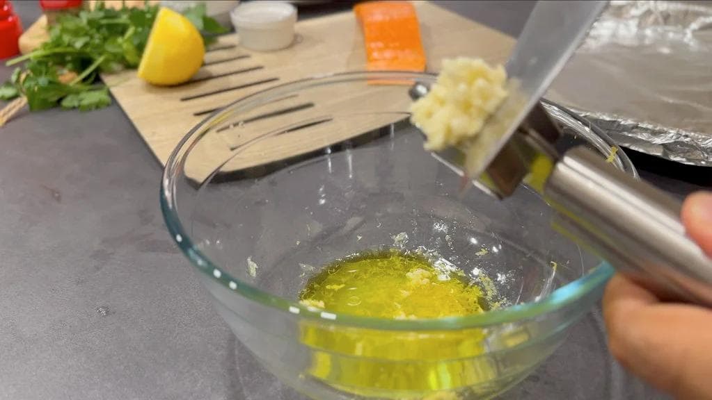 Lemon herb marinade with olive oil and lemon juice in a glass bowl, ready for salmon.