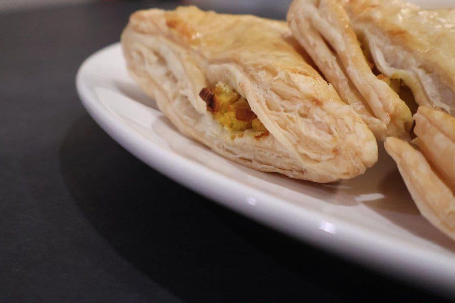 Golden-brown air fryer aloo patties with crispy puff pastry layers on a white plate.