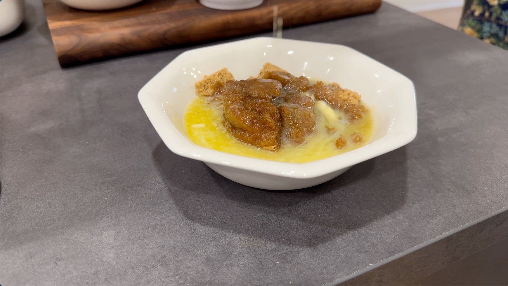 Melted butter and brown sugar mixture pooled in a white bowl on gray countertop.