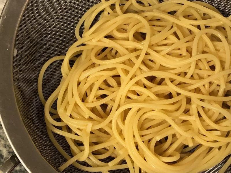 Cooked spaghetti draining in a colander before being added to the Cajun sauce.
