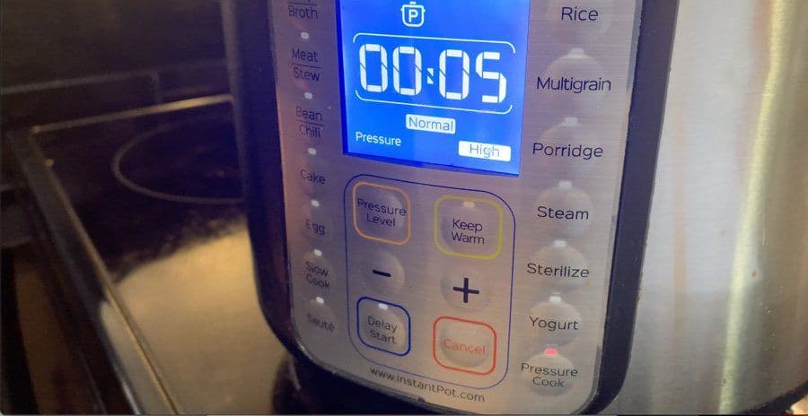 Instant Pot display showing 5 minutes cook time at high pressure for butter chicken curry.