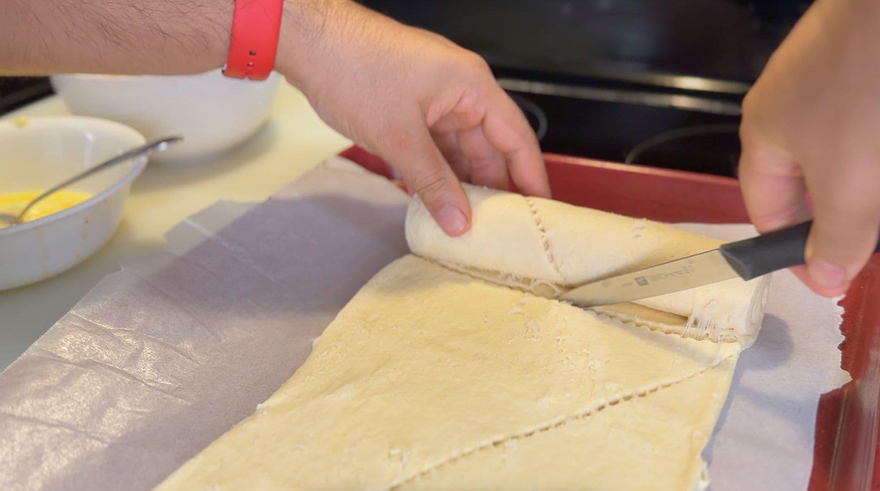 Rolling crescent roll dough into a cinnamon roll with butter and cinnamon sugar mixture.