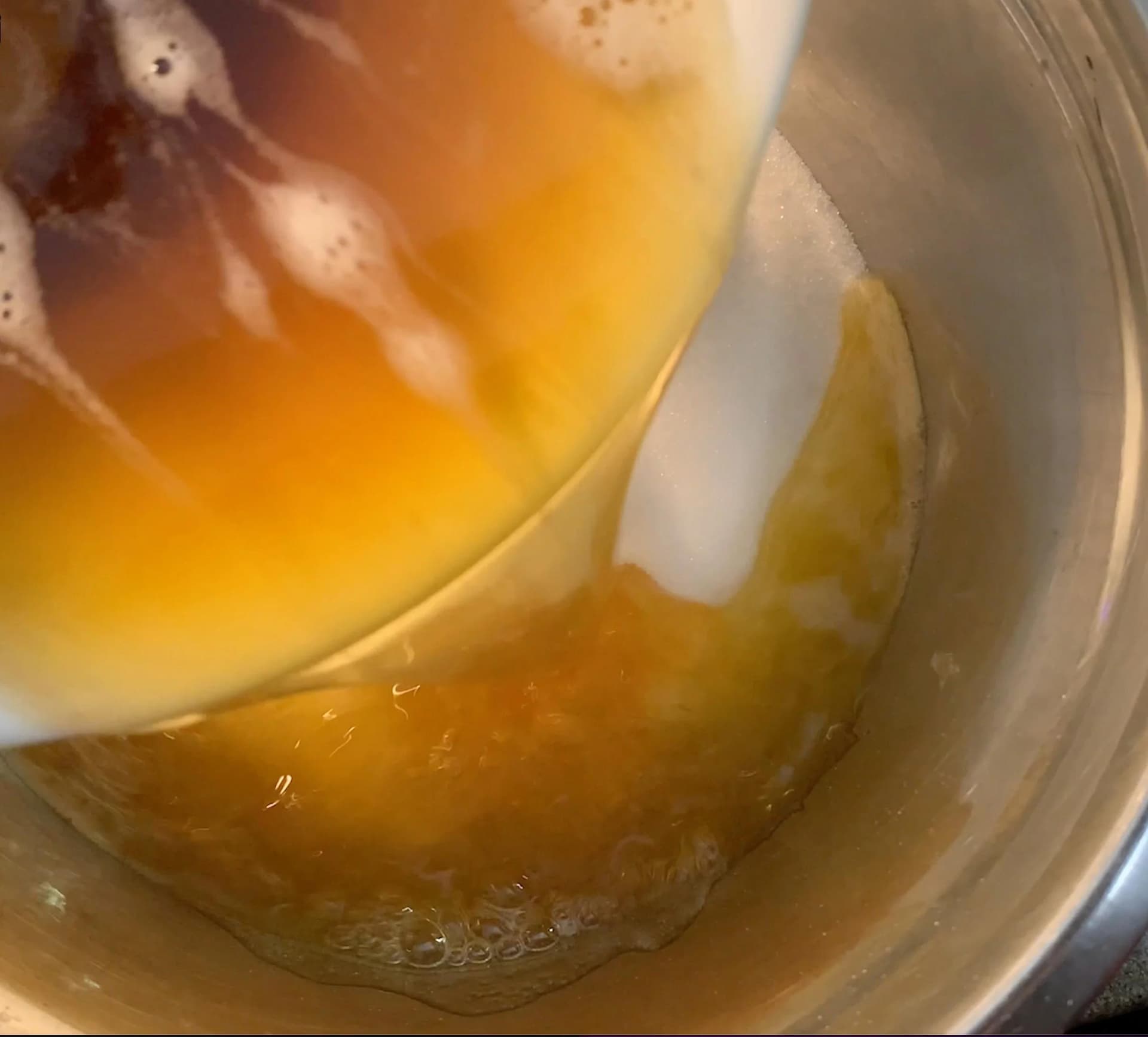 Browned butter being poured into a bowl of sugar for brownie batter.
