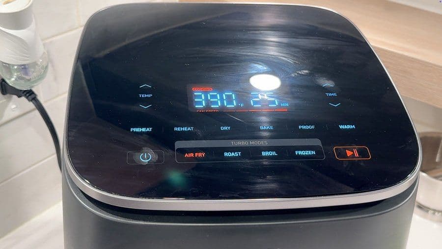 Digital air fryer display showing 390°F temperature setting for cooking potatoes.