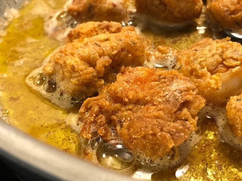 Breaded chicken and shrimp frying in golden oil until light golden brown