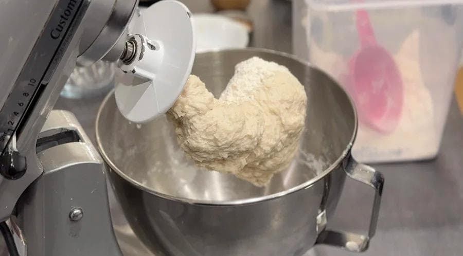 Stand mixer kneading dough for Beavertails in stainless steel bowl with dough hook attachment.