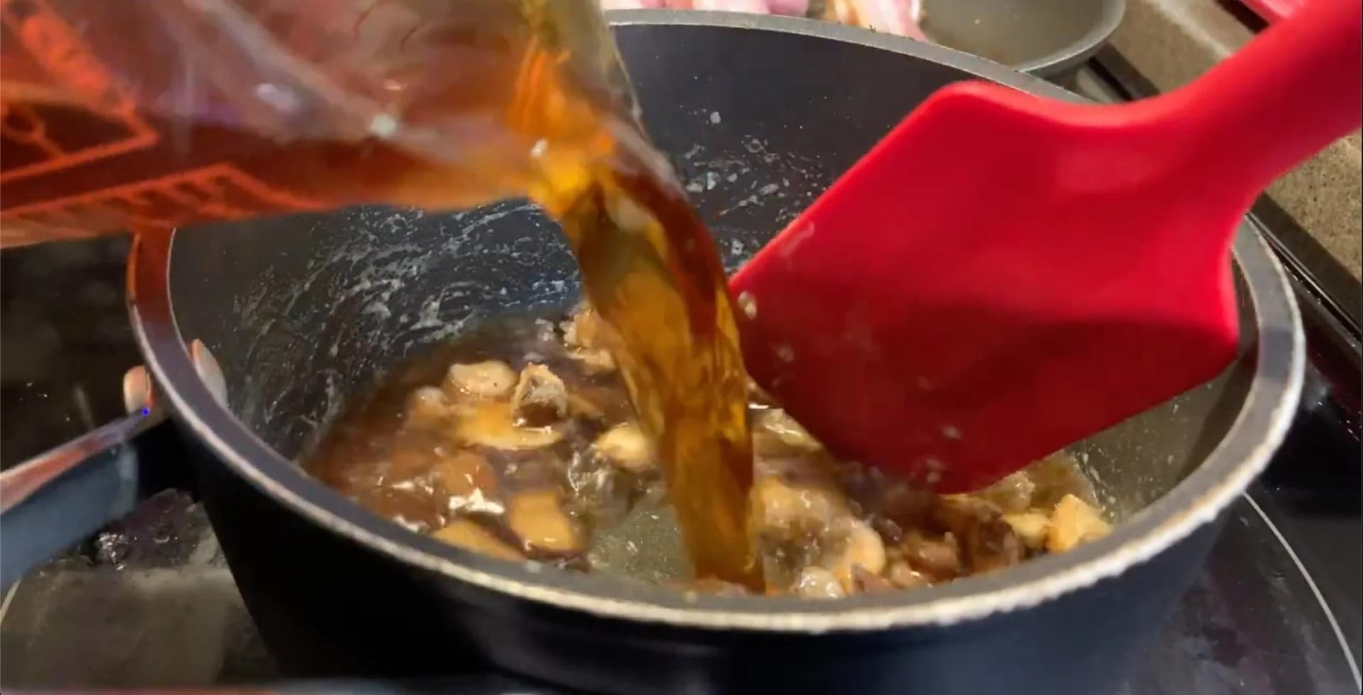 Beef stock being poured into a pot of cooked roux with mushrooms and bacon for poutine gravy.