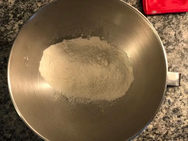 Flour mixed with oil in a stainless steel bowl for rumali roti dough preparation.