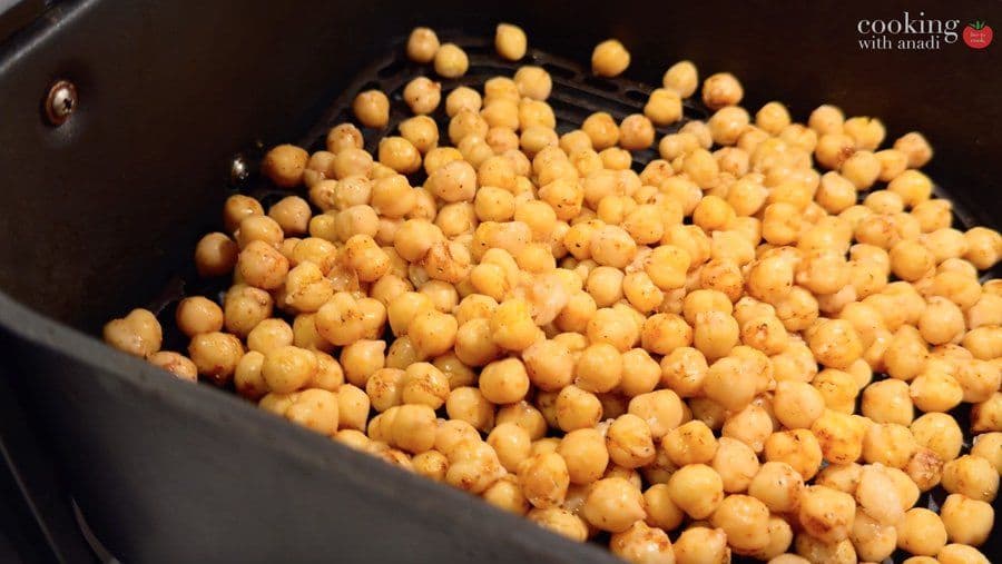 Cooked chickpeas in a dark pan, golden-brown and evenly roasted for air fryer recipe.