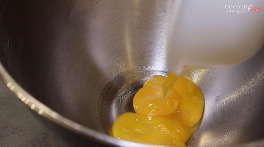 Egg yolks whisked to pale, thick ribbon stage in a stand mixer bowl