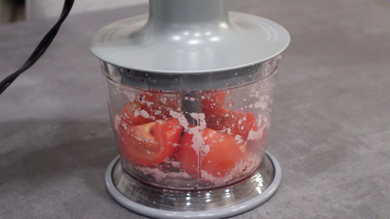 Tomatoes being pureed in a food processor for rajma masala preparation