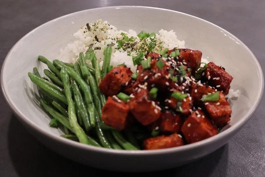 Crispy air fryer Korean tofu served with steamed rice, green beans, and garnished with sesame seeds and scallions.