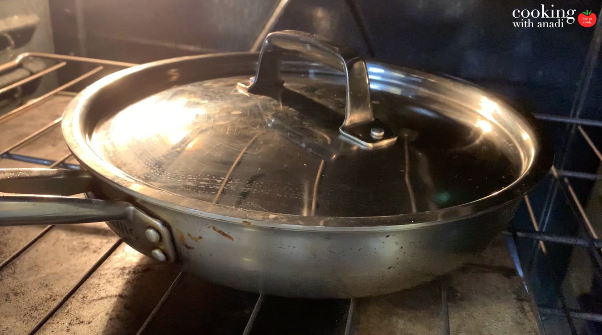 Covered pot with glass lid on stovetop during baking stage of one-pot chicken and rice dish.