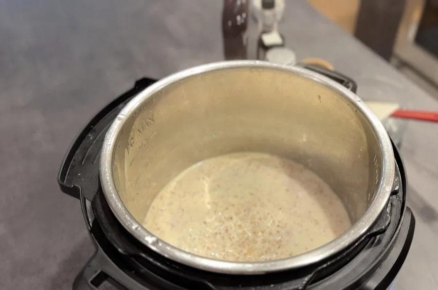 Cracked wheat and milk mixture in Instant Pot after pressure cooking, ready for sweeteners and flavoring additions.