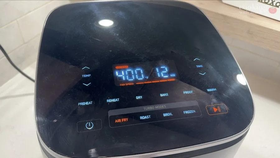 Air fryer display showing 400°F temperature with various cooking modes including air fry, roast, bake, and broil options visible.
