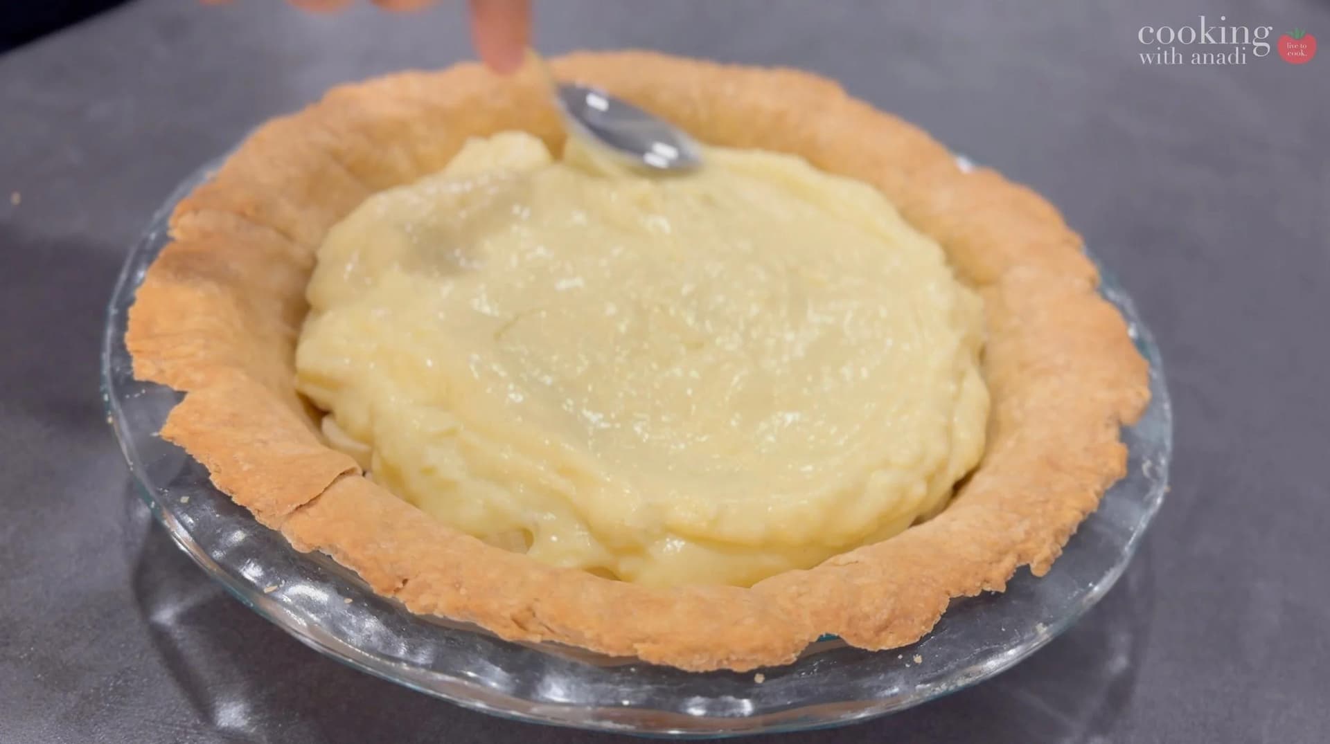 Banana cream pie with golden crust filled with creamy custard filling in a glass pie dish.