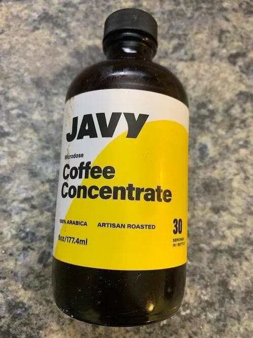 Javvy brand coffee concentrate bottle with yellow label on granite countertop
