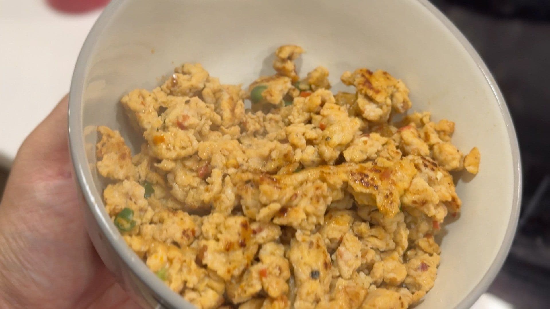 Cooked Italian sausage in a white bowl, browned and crumbled, ready to be added to the pasta dish.